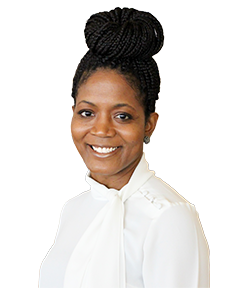 Smiling woman with braided hair styled in a high bun, wearing a white blouse with a bow collar.