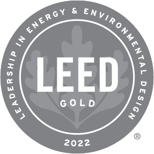 Gold LEED certification badge with stylized leaf design.